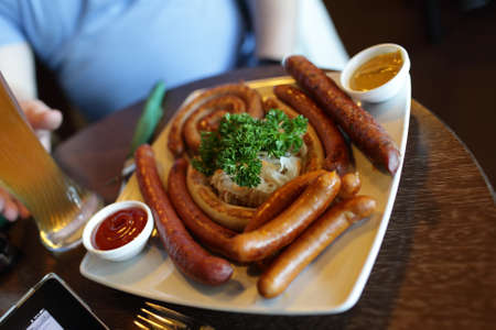 The various grilled sausages on a plate in the pubの写真素材