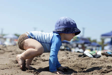 Toddler is crawling on a beach of Faliraki, Rhodes, Greeceの写真素材