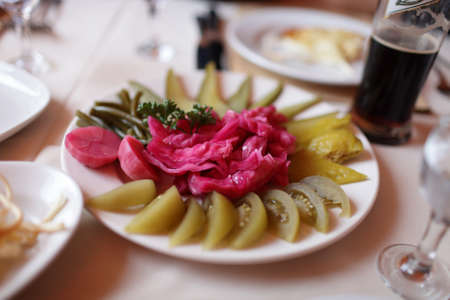 Pickled vegetables on a white plate in a tavernaの写真素材