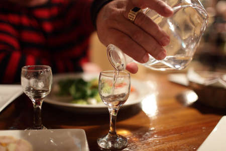 Person is pouring vodka in a bar in the eveningの写真素材