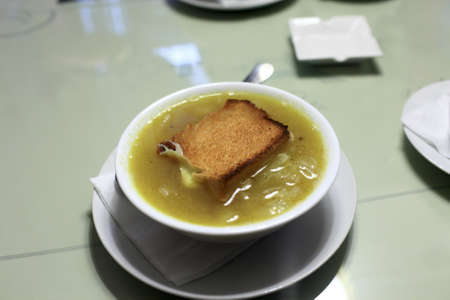 Plate of onion soup on a table in a french restaurantの写真素材