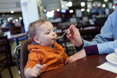 Toddler is eating soup from a motherの写真素材