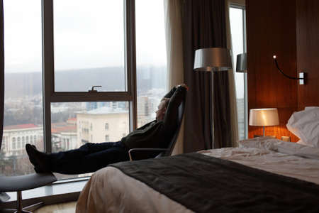 The mid adult man is resting in a hotel roomの写真素材
