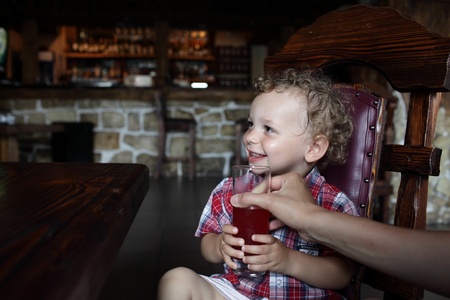 The child has juice in the restaurantの写真素材
