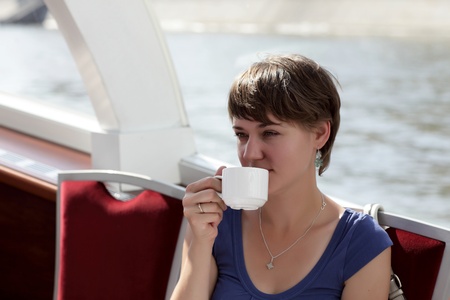 Woman with cup of tea on a yachtの写真素材