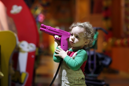 Boy holding a gun at indoor playgroundの写真素材