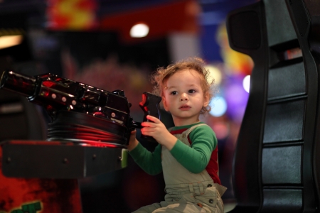 Child shoots a machine gun at indoor playgroundの写真素材