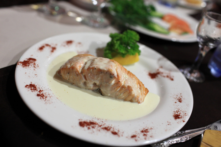 Steak of salmon on a white plate in the restaurantの写真素材
