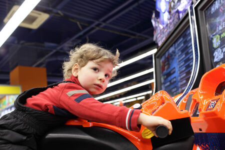Toddler driving motorbike toy at an amusement parkの写真素材
