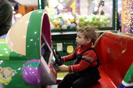 Child driving car toy at an amusement parkの写真素材