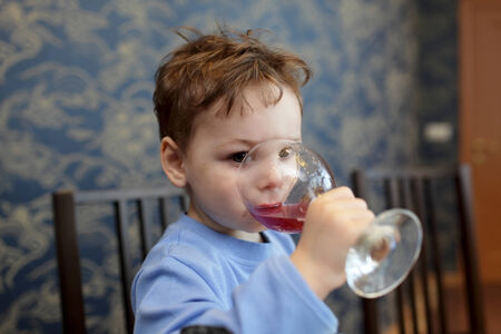 The child drinks juice in a restaurantの写真素材