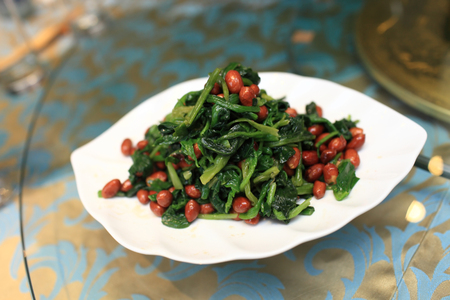 Spinach and crispy peanuts salad with aged vinegar in a chinese restaurantの写真素材