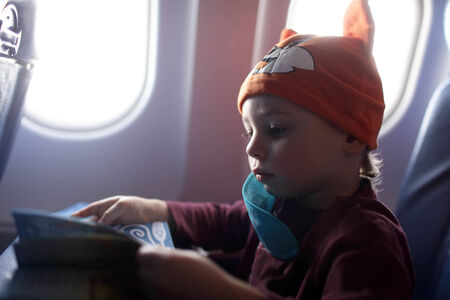 The child with book in the airplaneの写真素材