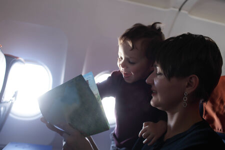 Family with a book in an airplaneの写真素材
