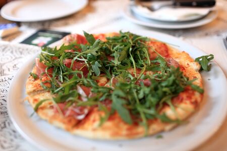Pizza with arugula on a plate in the czech restaurantの写真素材
