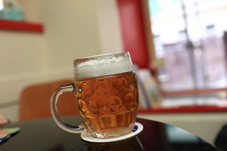 Mug of beer on the table in a cafeの写真素材