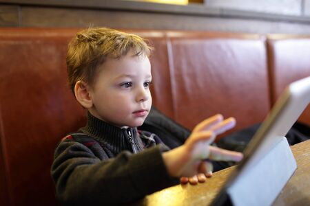 Child playing on a Tablet PC in the restaurant