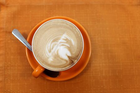 Cup of cappuccino on a tablecloth in the cafe