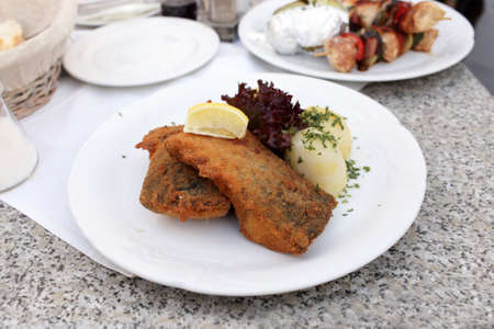 Fried carp with potatoes and slice of lemon in the czech restaurantの写真素材