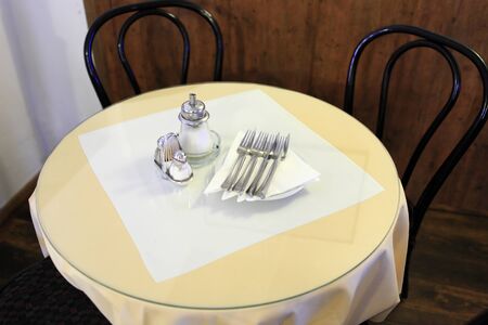 The yellow round dining table with cutleryの写真素材