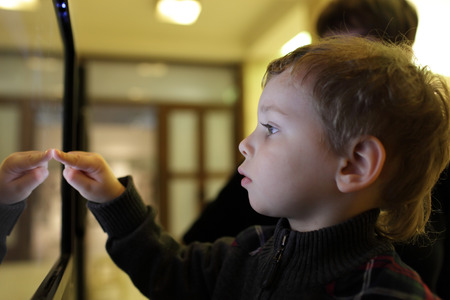 Boy using interactive touch screen in a museumの写真素材