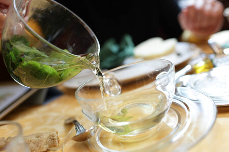 Girl pouring mint tea in the cafeの写真素材