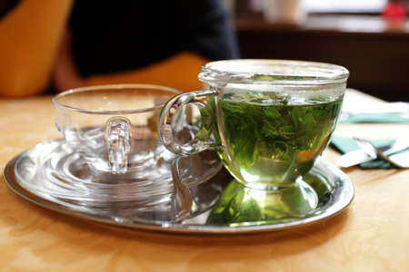Glass teapot with mint tea in the cafeの写真素材
