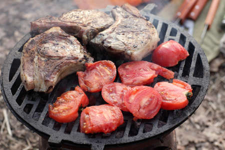 Pork and tonatoes on a barbecue grillの写真素材