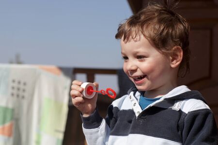 Happy child playing with soap bubble outdoorの写真素材