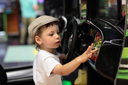 Child playing arcade game machine at an amusement parkの写真素材