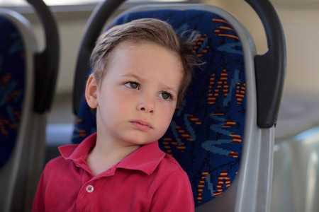 The tired boy sitting in a train
