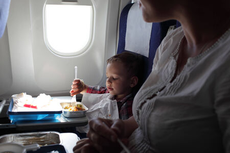 Mother and her son have lunch on a flightの写真素材
