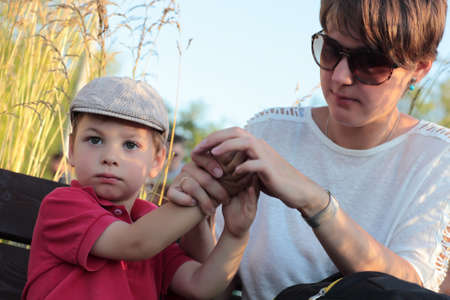 Mother cleans hands her son in the park