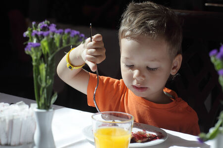 Child has breakfast at cafe in the morningの写真素材
