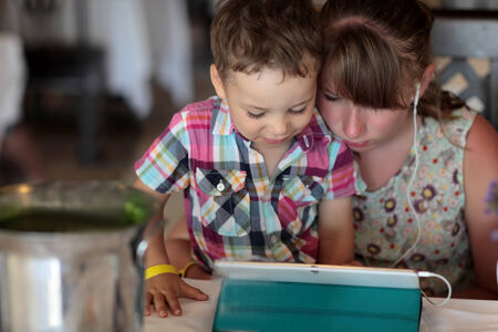 Children using tablet PC in a restaurant