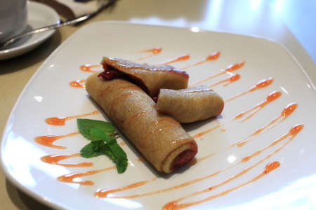 Stuffed pancakes with sweet sauce on a plateの写真素材