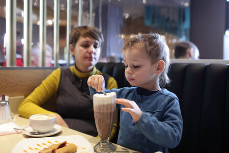 Child eating foam of milkshake in the restaurantの写真素材