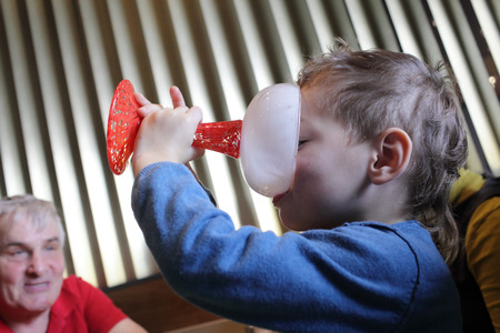 Boy licking a plate of ice cream in the restaurantの写真素材