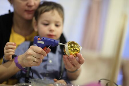 Family decorating a Christmas toy in the classroom