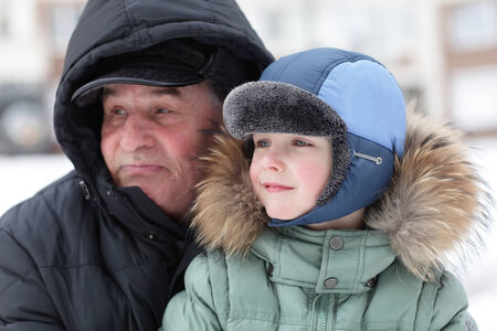 Grandfather with grandson in a winter parkの写真素材