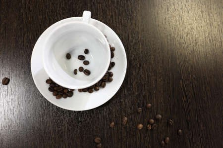 Cup with coffee beans on a wooden table