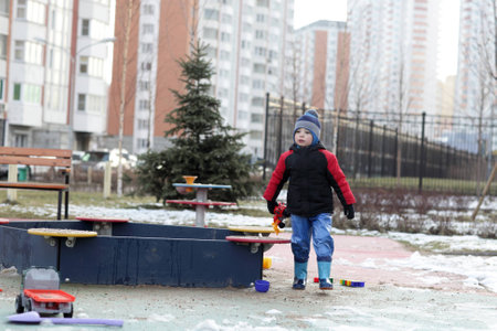 Boy playing with toy in the sandbox at outdoor playground in springの写真素材