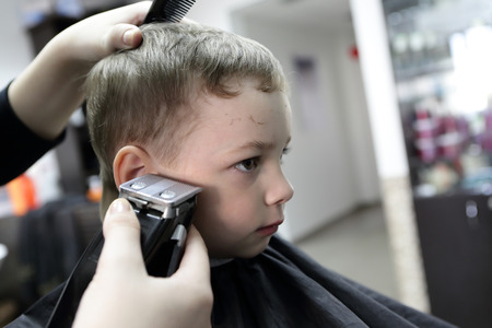 Portrait of a serious child at the barbershopの写真素材