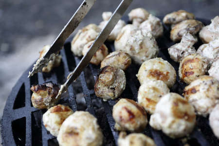 Cooking mushrooms on the barbecue grill at picnicの写真素材