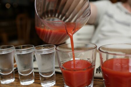 Person pouring tomato juice in the pubの写真素材