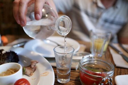 Bartender pouring vodka from the decanter in the pubの写真素材