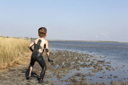 Child goes on healing mud in Primorsko-Akhtarsk, Russiaの写真素材
