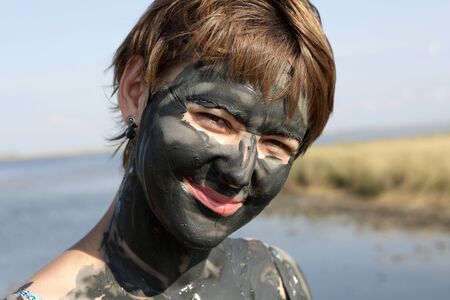 Woman face covered with black healthy mudの写真素材