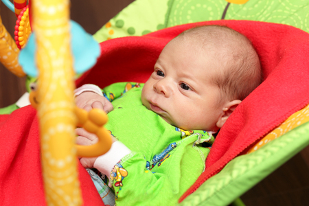 Portrait of a serious newborn in the rocking chairの写真素材