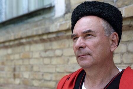 Portrait of a thinking Kuban Cossack on the wall background